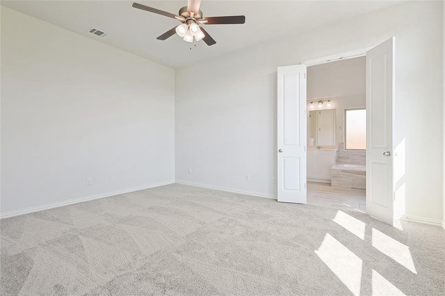 Carpeted spare room with ceiling fan