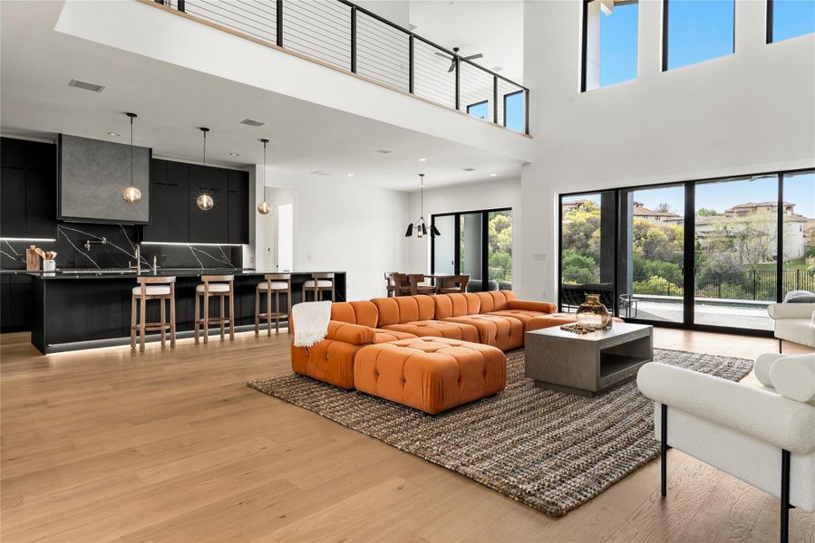 Living area with light wood-type flooring and a high ceiling Living area with light wood-type flooring and a high ceiling