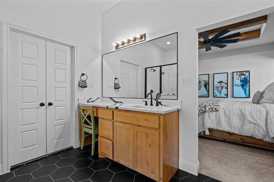 Bathroom featuring ceiling fan, tile patterned flooring, vanity, and an enclosed shower