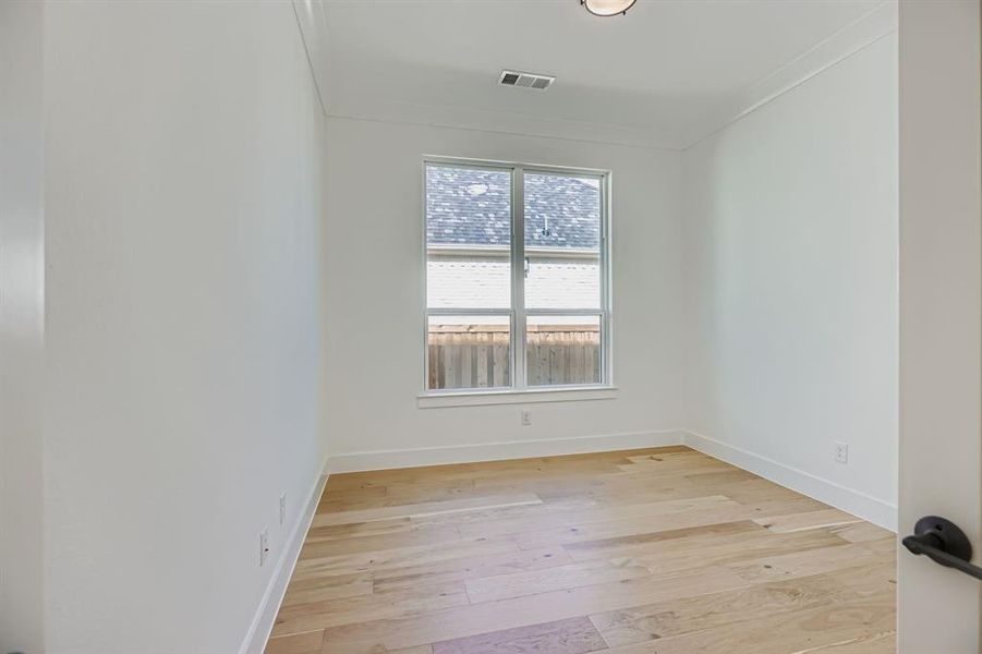 Spare room featuring light wood finished floors and ornamental molding