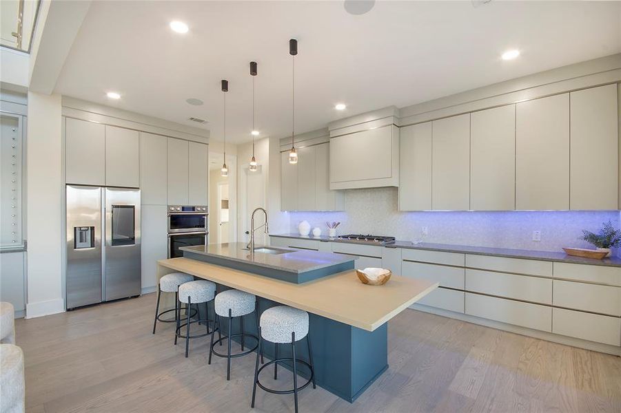 Kitchen with modern cabinets, appliances with stainless steel finishes, pendant lighting, light wood-type flooring, and recessed lighting Kitchen with modern cabinets, appliances with stainless steel finishes, pendant lighting, light wood-type flooring, and recessed lighting