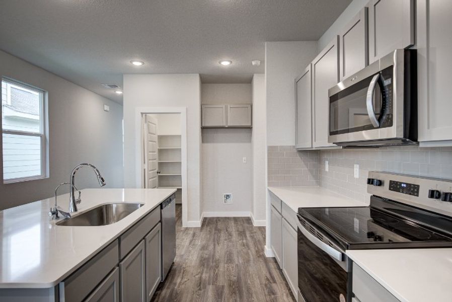 A kitchen with white cabinets.