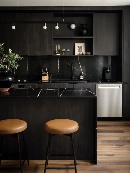 Dramatic dark cabinetry and matching stone counters anchor this contemporary kitchen design. Dramatic dark cabinetry and matching stone counters anchor this contemporary kitchen design.