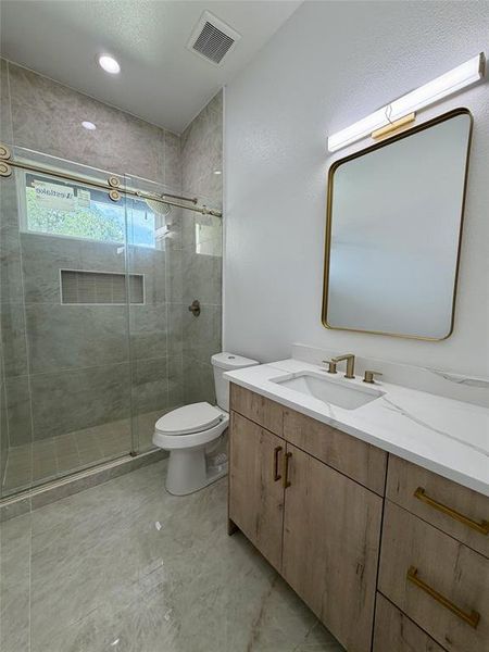 Modern bathroom featuring a wood-finish vanity with a white countertop and integrated sink 1st floor Modern bathroom featuring a wood-finish vanity with a white countertop and integrated sink 1st floor