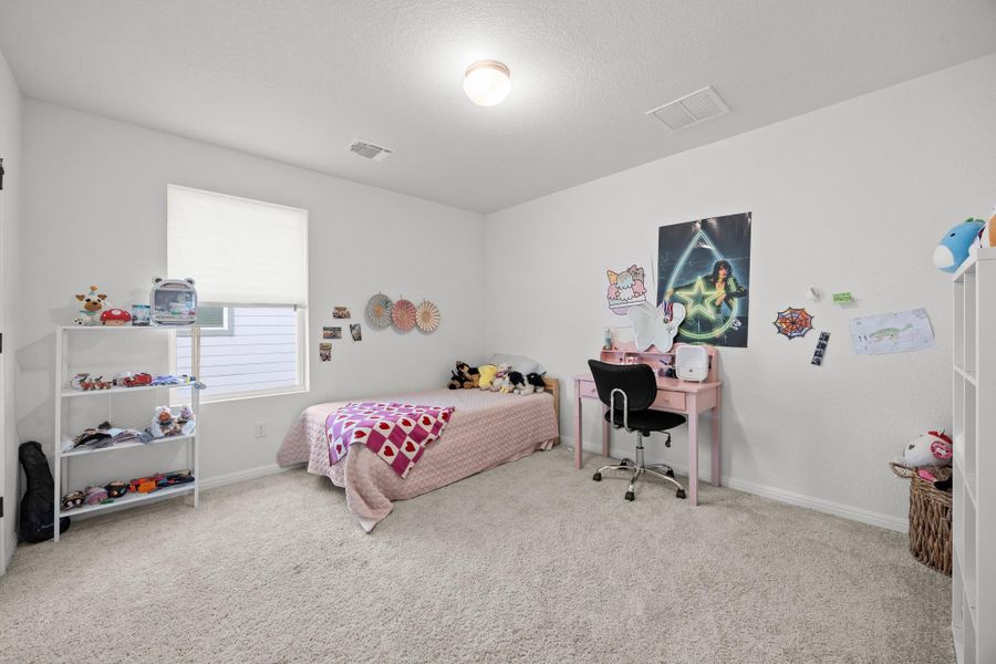 Carpeted room featuring a single window with a white privacy blind, light-colored walls, and a ceiling-mounted light fixture