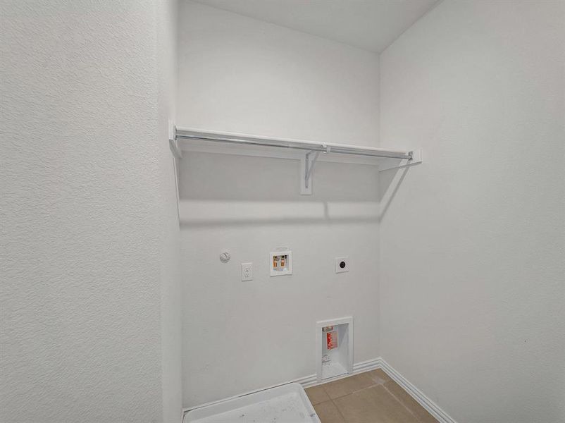 Washroom featuring hookup for a washing machine, hookup for a gas dryer, electric dryer hookup, and light tile patterned flooring