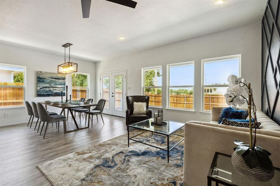 Living room with a textured ceiling, hardwood / wood-style flooring, french doors, and ceiling fan