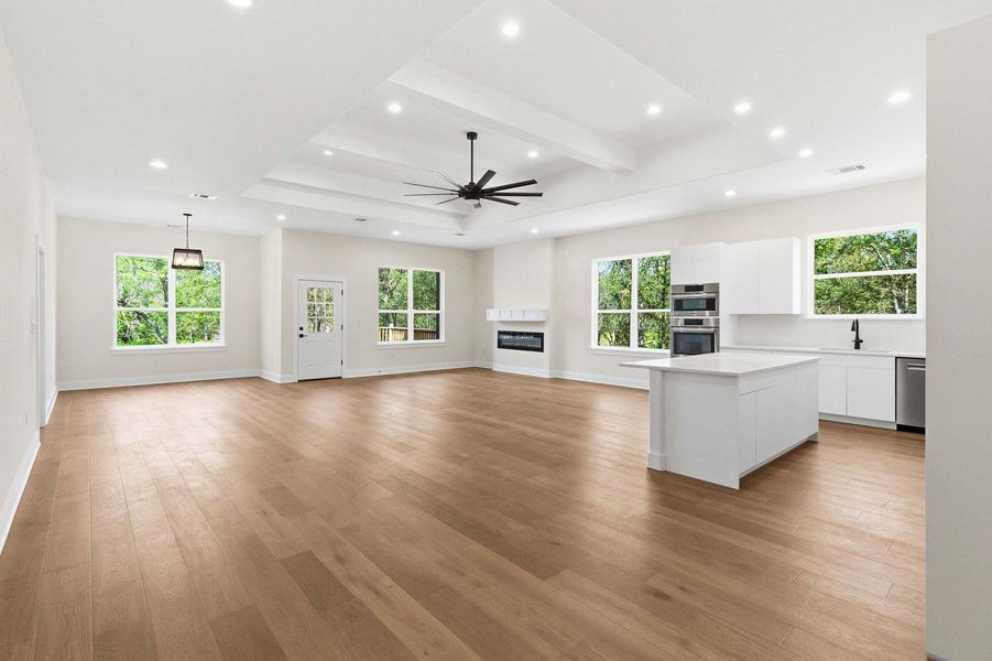 An open concept living space features abundant natural light, a sleek kitchen island, and a contemporary fireplace feature. An open concept living space features abundant natural light, a sleek kitchen island, and a contemporary fireplace feature.