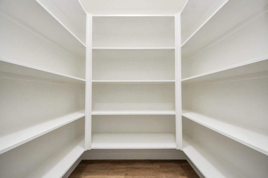 A generous walk-in pantry designed for both function and style—crisp white shelving keeps everything neatly in place
