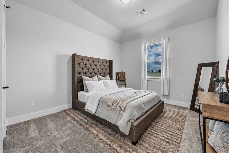 Carpeted room with a single window featuring blinds and white curtains