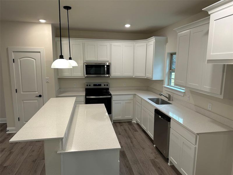 Kitchen with stainless steel appliances, a sink, plenty of  cabinets and counter space, a large island and pantry.