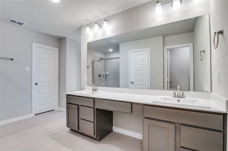 Full bathroom with a shower stall, double vanity, recessed lighting, and light tile patterned floors Full bathroom with a shower stall, double vanity, recessed lighting, and light tile patterned floors