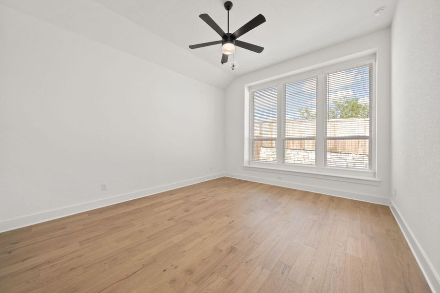 Unfurnished room featuring light wood-style floors, a ceiling fan, and lofted ceiling