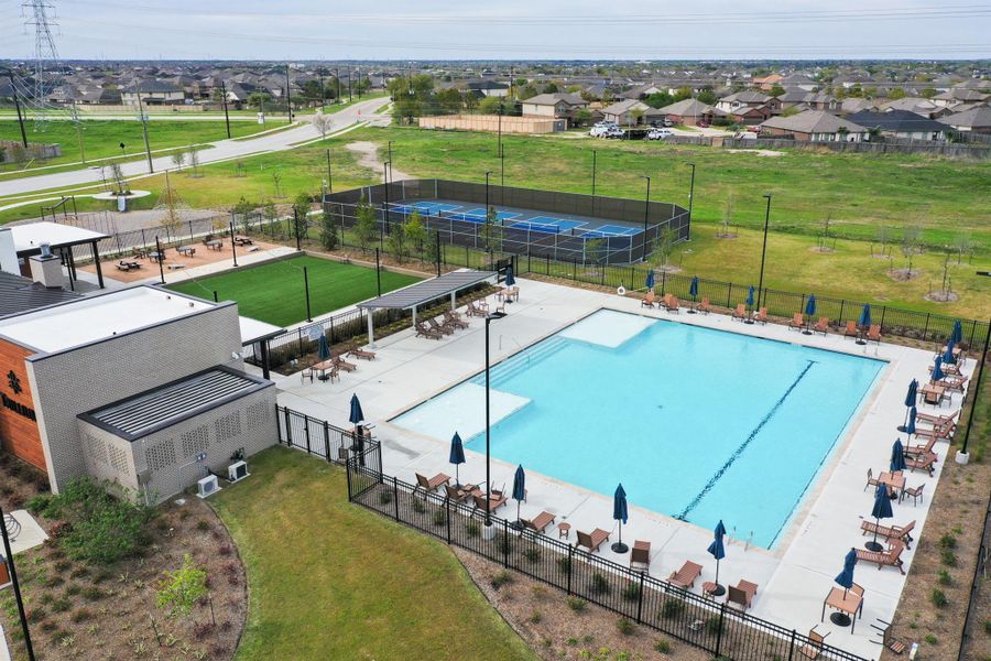 Resort-style community amenities featuring a sparkling pool, spacious sun deck, and shaded pavilion for relaxing or hosting gatherings. Residents also enjoy four pickleball courts, a playground, open green spaces, and walking paths—perfect for an active and family-friendly lifestyle.