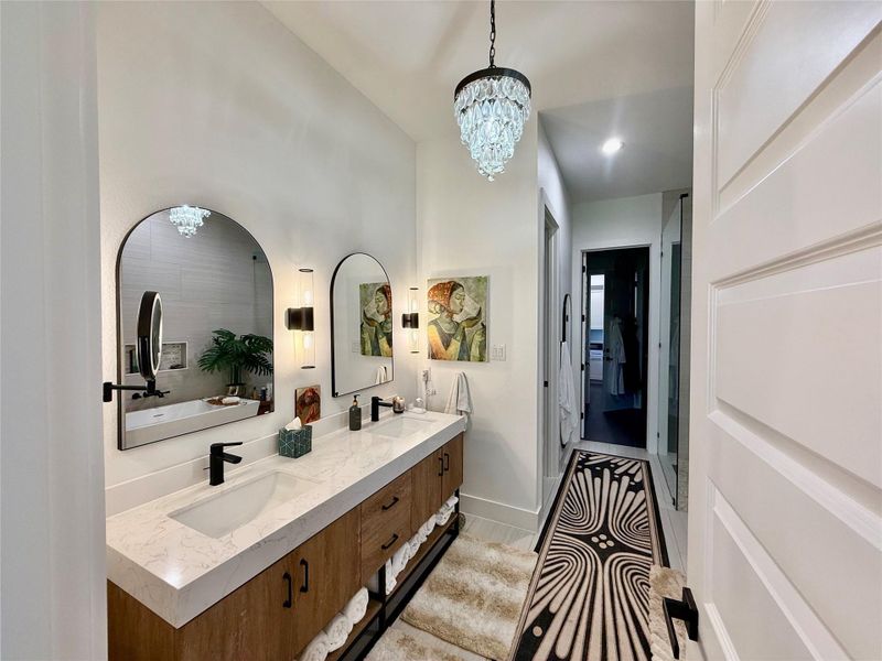 Dual vanity featuring a light-toned countertop, wood-finish cabinetry, and matte black fixtures