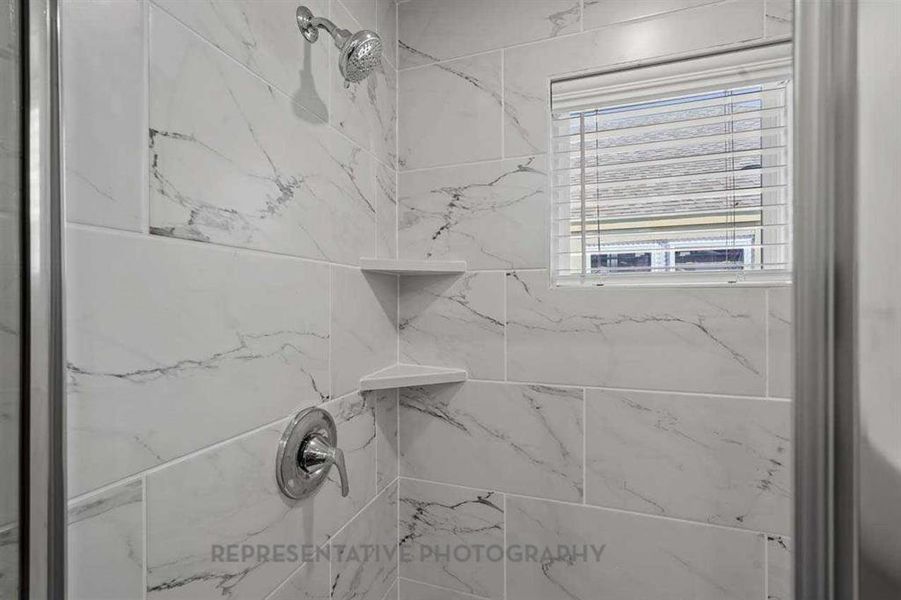 Full bathroom with a marble finish shower
