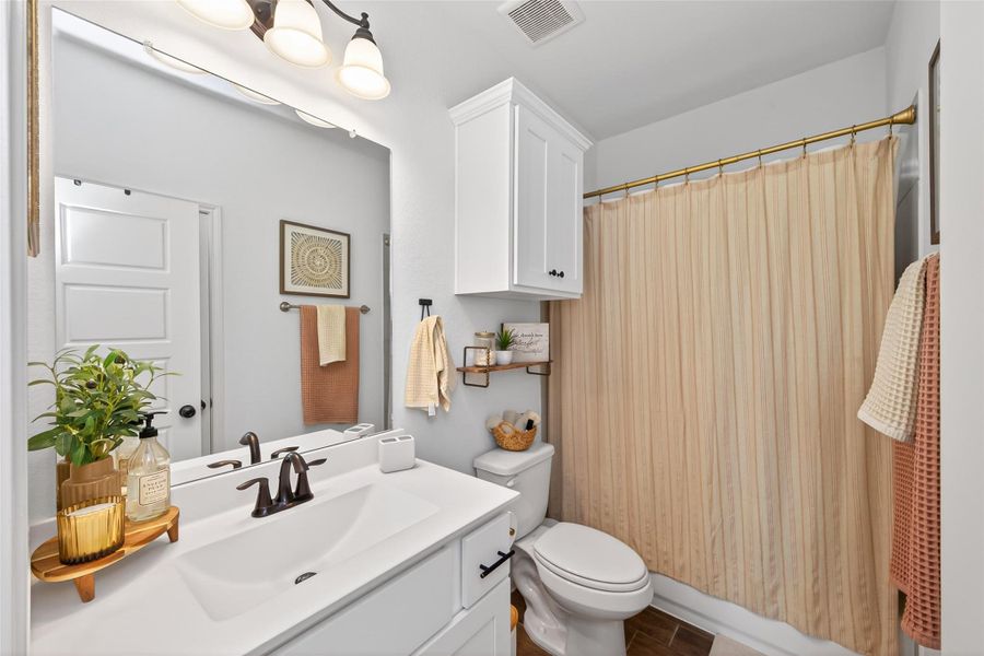 Secondary bathroom features custom built cabinet above toilet with tub/shower combo with linen closet. Secondary bathroom features custom built cabinet above toilet with tub/shower combo with linen closet.