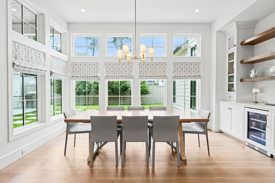 Tucked just off the kitchen, a closer view of the charming breakfast area, filled w/ natural light from a corner wall of Sierra Pacific windows overlooking the backyard. A Visual Comfort light fixture adds a subtle design moment, while the built-in dry bar w/ Taj Mahal quartzite countertop, beverage fridge & display shelving enhances both function & everyday ease. Bright, inviting & seamlessly connected to the heart of the home. Tucked just off the kitchen, a closer view of the charming breakfast area, filled w/ natural light from a corner wall of Sierra Pacific windows overlooking the backyard. A Visual Comfort light fixture adds a subtle design moment, while the built-in dry bar w/ Taj Mahal quartzite countertop, beverage fridge & display shelving enhances both function & everyday ease. Bright, inviting & seamlessly connected to the heart of the home.
