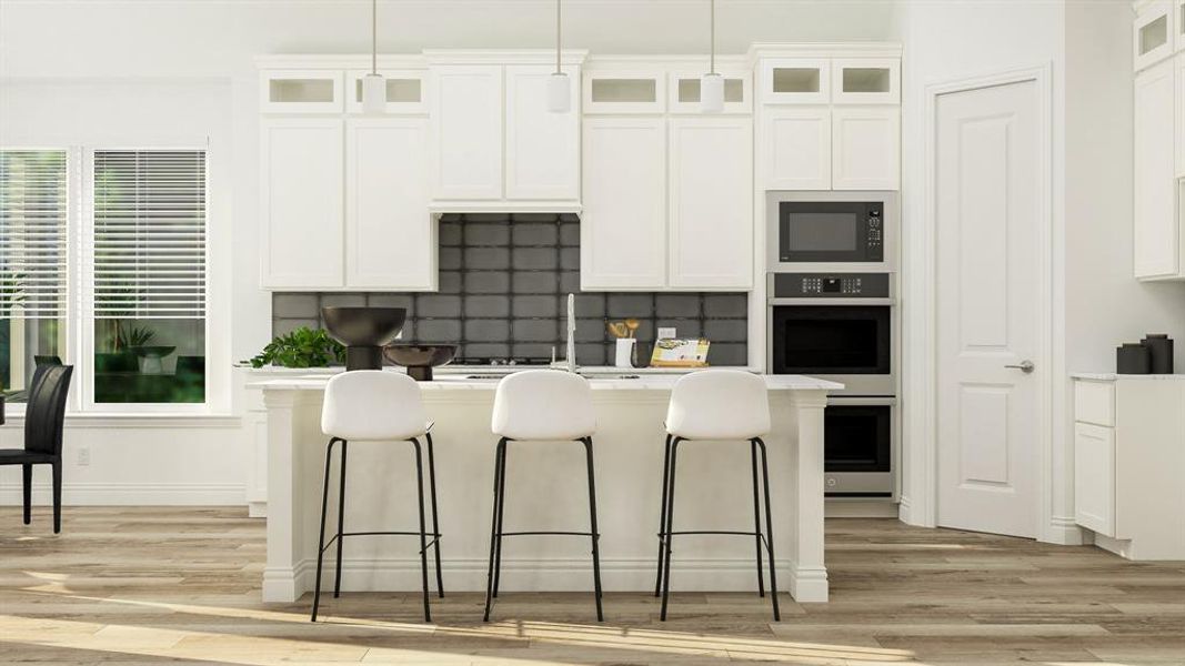 Kitchen featuring tasteful backsplash, white cabinets, pendant lighting, and black microwave