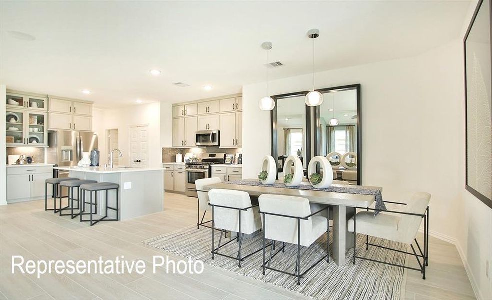 Open-concept kitchen and dining area featuring light wood-finish flooring