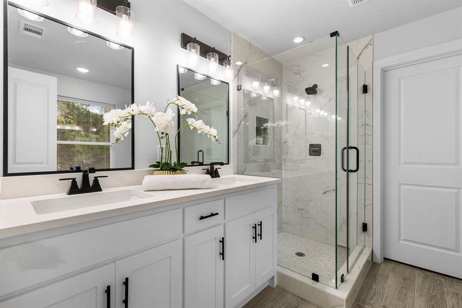 Bathroom with hardwood / wood-style floors, vanity, and walk in shower