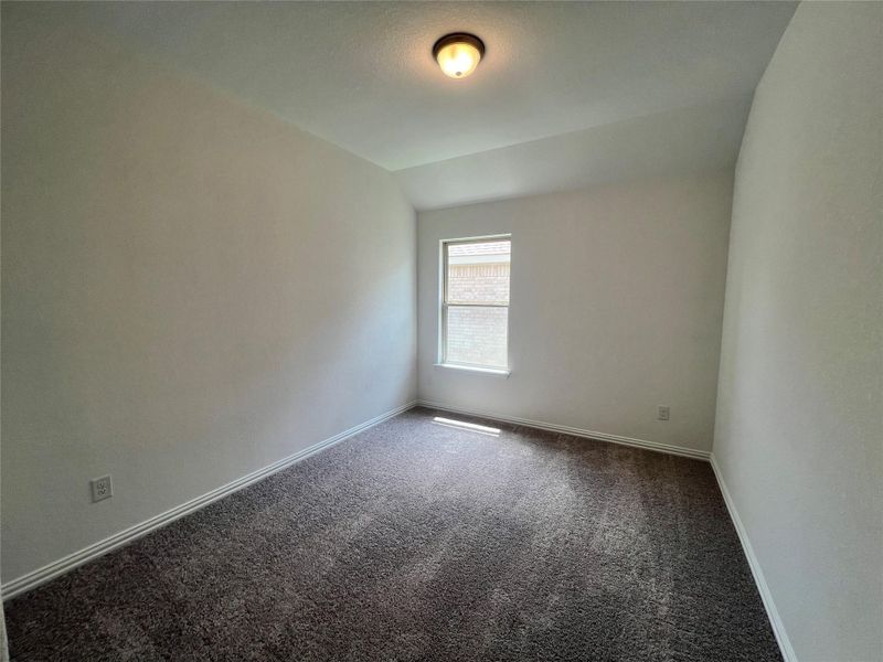 Carpeted spare room with lofted ceiling and baseboards