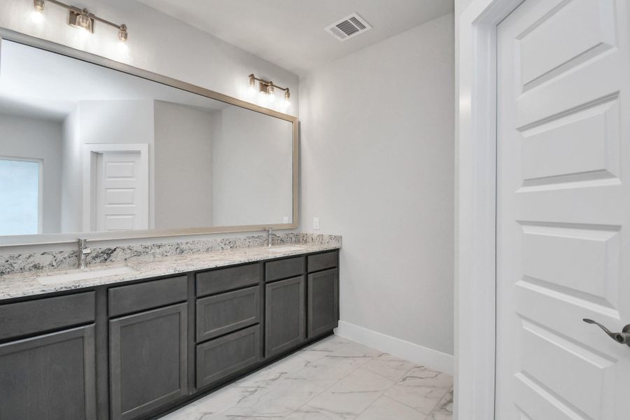 Escape to a spa-like oasis in this primary bathroom. Enjoy a walk-in shower with tile surround, a separate garden tub with custom detailing, and an elegant vanity featuring light countertops, modern hardware, and beautiful vanity lights. Experience luxury and relaxation in every detail. Escape to a spa-like oasis in this primary bathroom. Enjoy a walk-in shower with tile surround, a separate garden tub with custom detailing, and an elegant vanity featuring light countertops, modern hardware, and beautiful vanity lights. Experience luxury and relaxation in every detail.
