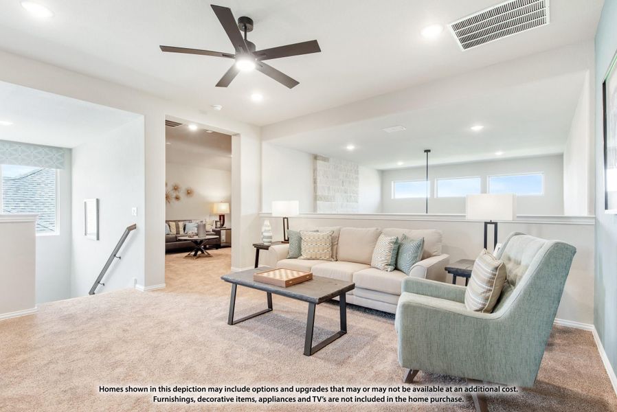 Upstairs loft or bonus room with ceiling fan, carpet, sofa, and accent chair overlooking staircase Upstairs loft or bonus room with ceiling fan, carpet, sofa, and accent chair overlooking staircase