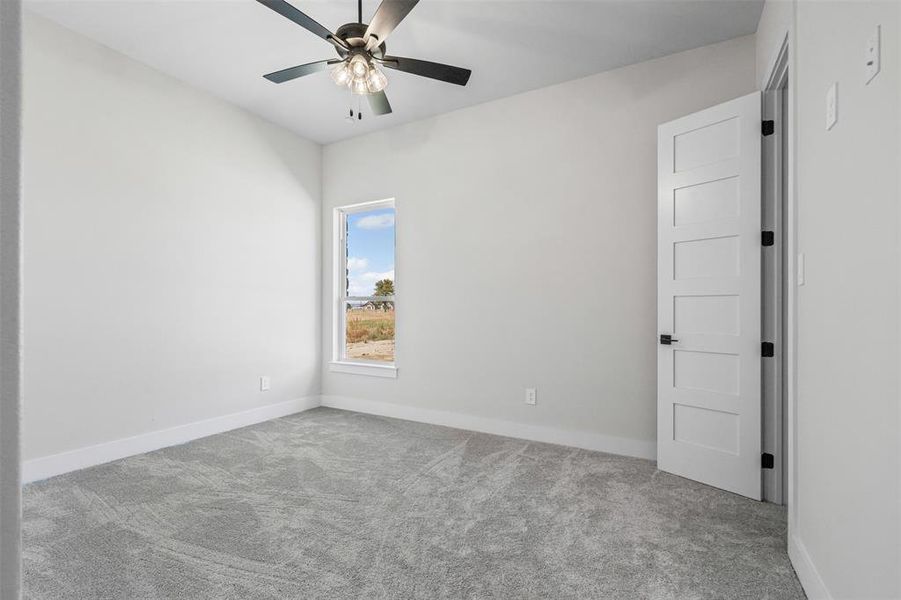 Spare room featuring light carpet and a ceiling fan
