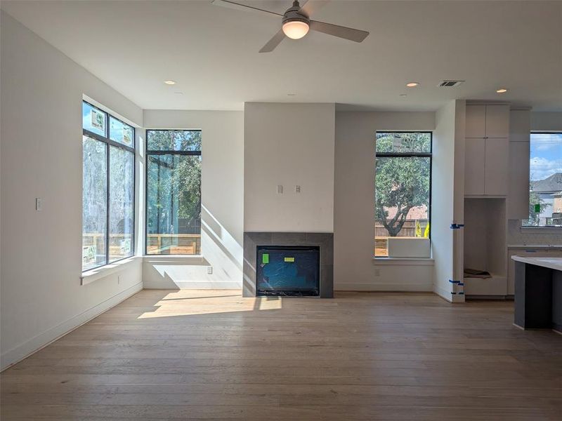 Living room with fireplace and large floor to ceiling windows.