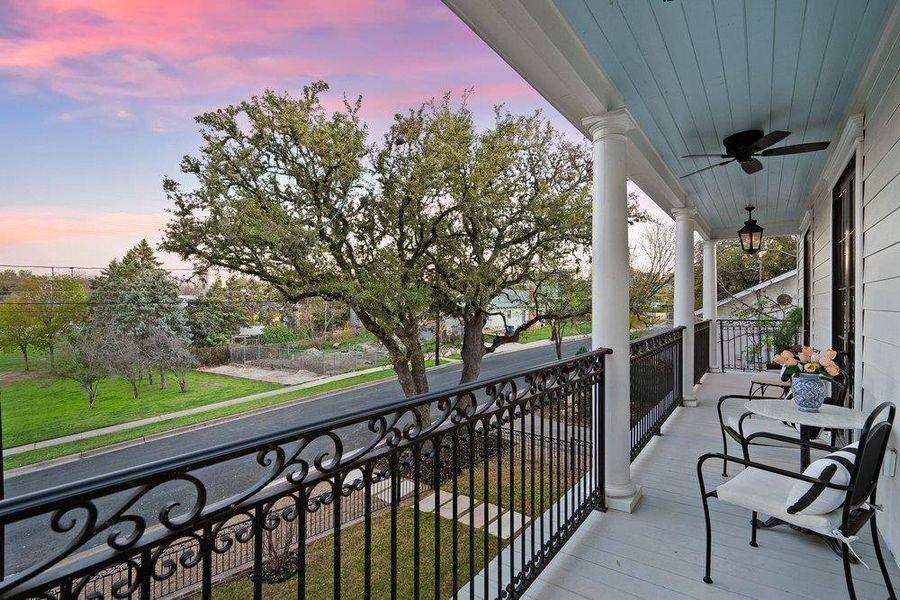 Balcony at dusk with a ceiling fan and covered porch
