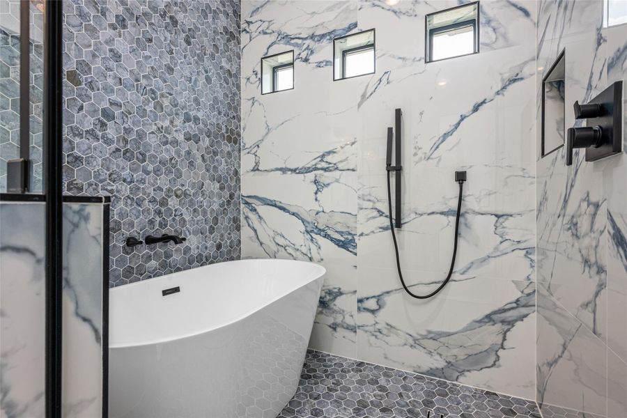 Step into a true spa shower experience—porcelain-tiled to the ceiling with three shower heads: rainfall, handheld, and wall-mounted—all inside the standalone tub enclosure