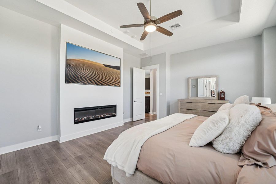 A tray ceiling and electric fireplace add architectural detail and warmth to the space.