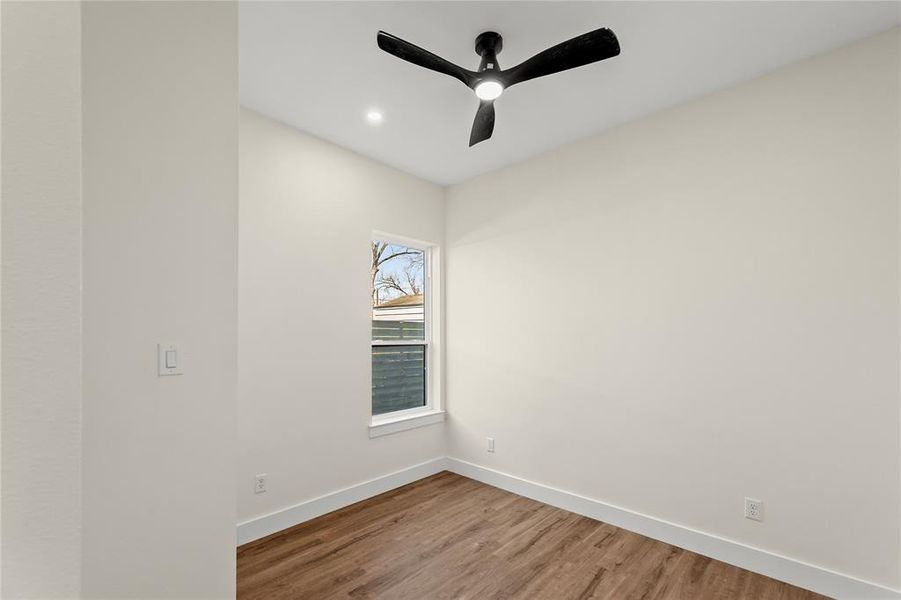 Empty room featuring ceiling fan, wood finished floors, and recessed lighting