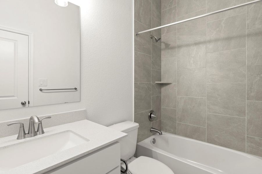 Bathroom featuring shower / bath combination, vanity, and a textured wall
