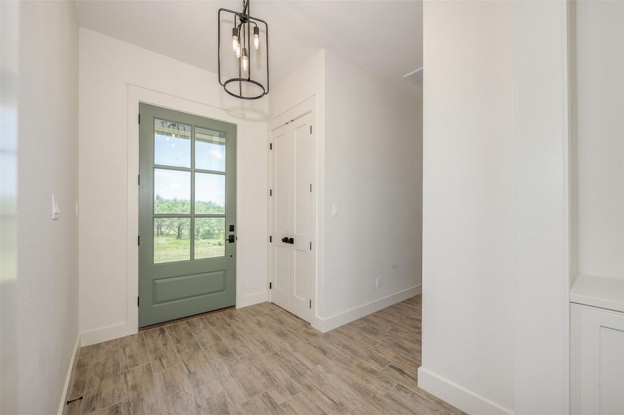 Entryway featuring wood finished floors and a chandelier