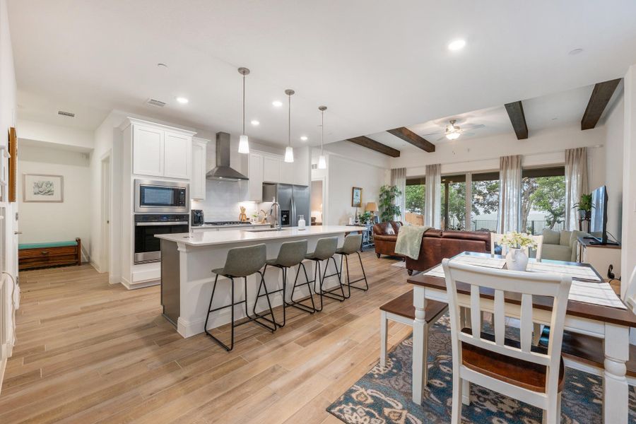 An open concept living area boasts a modern kitchen with a large island and ample seating, flowing into a spacious living room. An open concept living area boasts a modern kitchen with a large island and ample seating, flowing into a spacious living room.