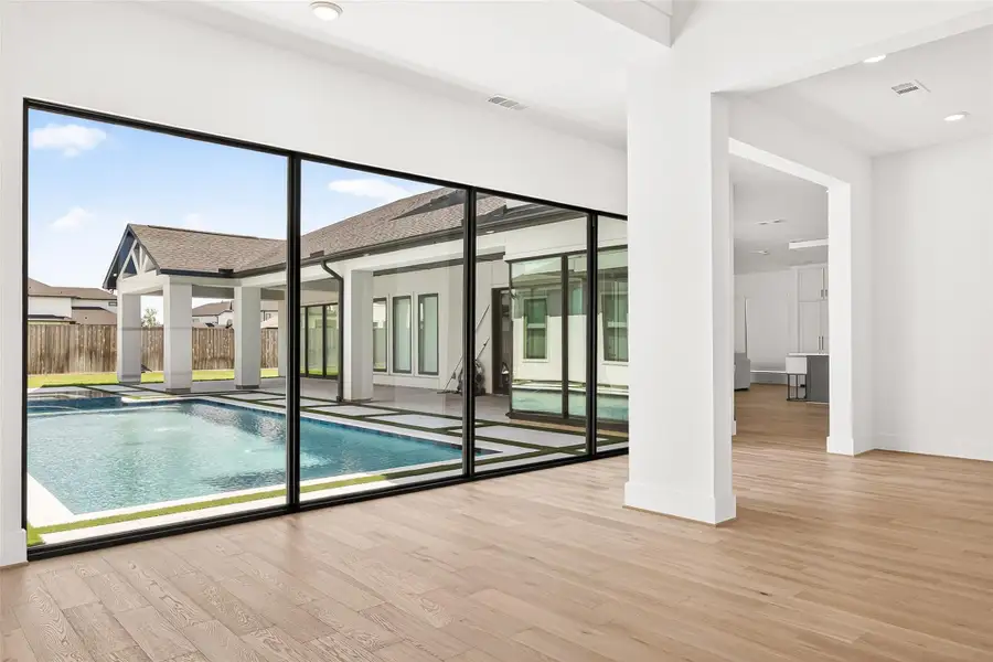 Engineered wood flooring flows throughout the home, while black window frames, white interior walls, raised ceilings, oversized baseboards, and 8-foot doors create a clean, modern aesthetic with timeless elegance.