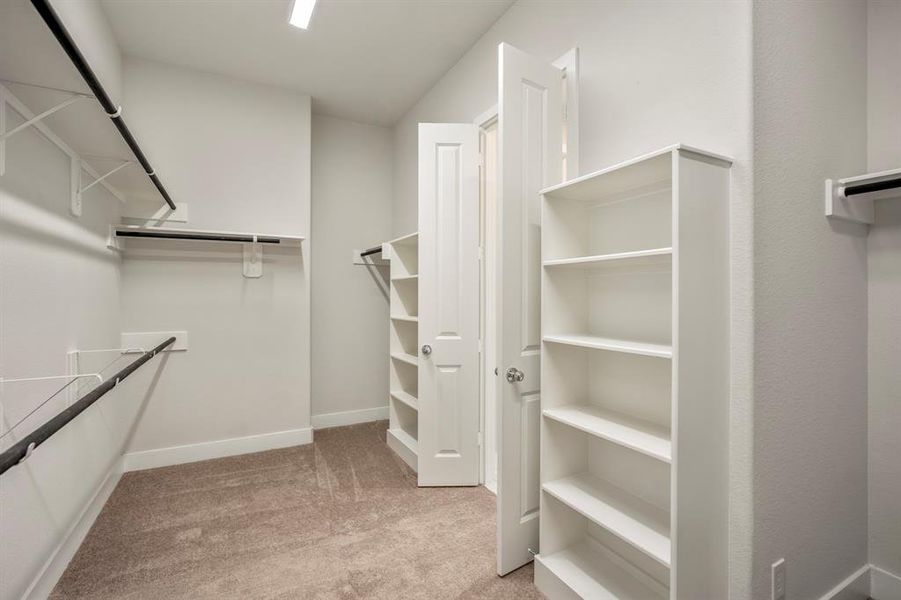 Step into a realm of organization in this expansive walk-in closet, a key feature of the primary suite. Offering ample shelving and hanging space, embrace the joy of a perfectly curated space where fashion meets function!