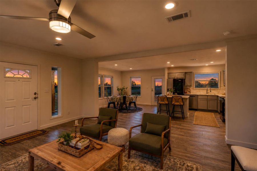 An open floorplan seamlessly connects the welcoming living area, a cozy dining space, and a well-appointed kitchen, all bathed in soft evening light. An open floorplan seamlessly connects the welcoming living area, a cozy dining space, and a well-appointed kitchen, all bathed in soft evening light.