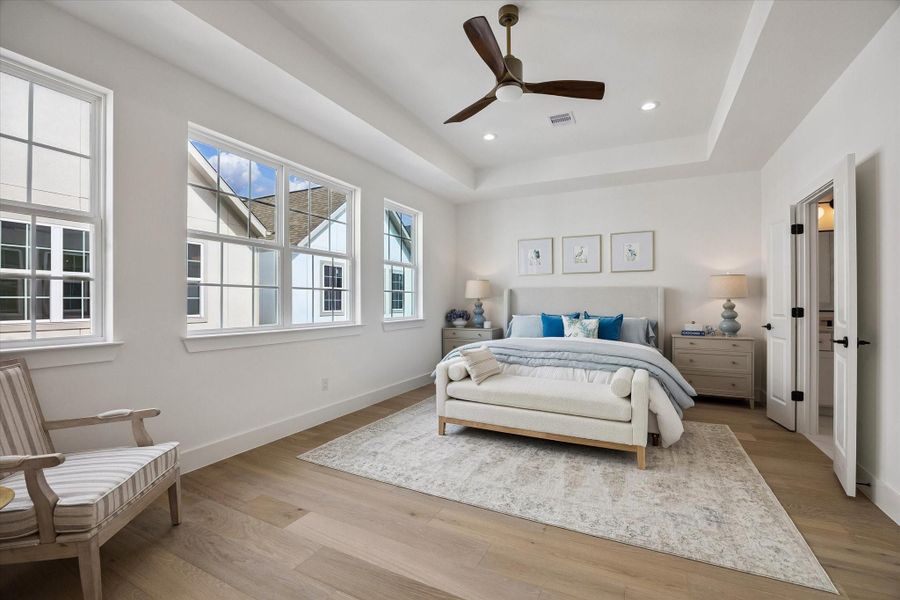 The primary bedroom features soaring ceilings and ample space for private relaxation.