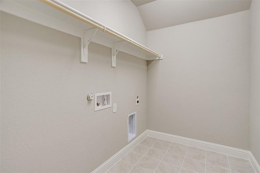 Laundry area featuring light tile patterned floors, hookup for a washing machine, hookup for a gas dryer, and hookup for an electric dryer Laundry area featuring light tile patterned floors, hookup for a washing machine, hookup for a gas dryer, and hookup for an electric dryer