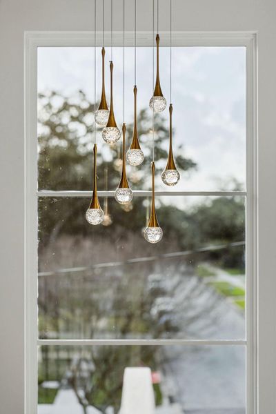 Suspended beautifully against a large picture window, the hand-blown glass globes with gold accents serve as a sculptural focal point that can be appreciated from both levels.