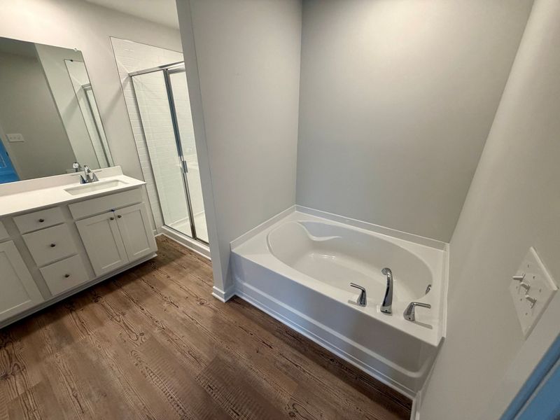 A bathroom with a tub and sink. A bathroom with a tub and sink.