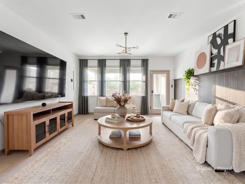 Spacious living area filled with natural light from oversized windows and a glass-paned door to the covered patio. The rich slatted feature wall and open flow to the kitchen create a warm, connected layout. This photo has been digitally staged to illustrate the possibilities of the home's aesthetic and potential design. Some furnishings and décor shown are for visual inspiration.