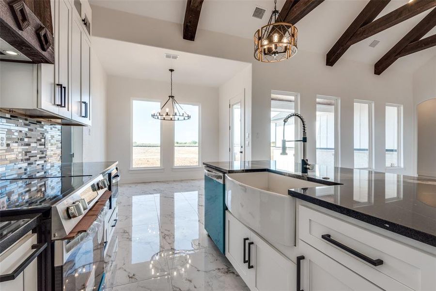 Kitchen featuring dishwashing machine, ventilation hood, visible vents, an inviting chandelier, and marble finish floor