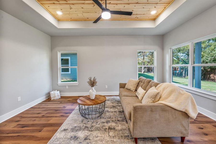 Living room featuring a tray ceiling, wooden ceiling, wood finished floors, recessed lighting, and ceiling fan Living room featuring a tray ceiling, wooden ceiling, wood finished floors, recessed lighting, and ceiling fan