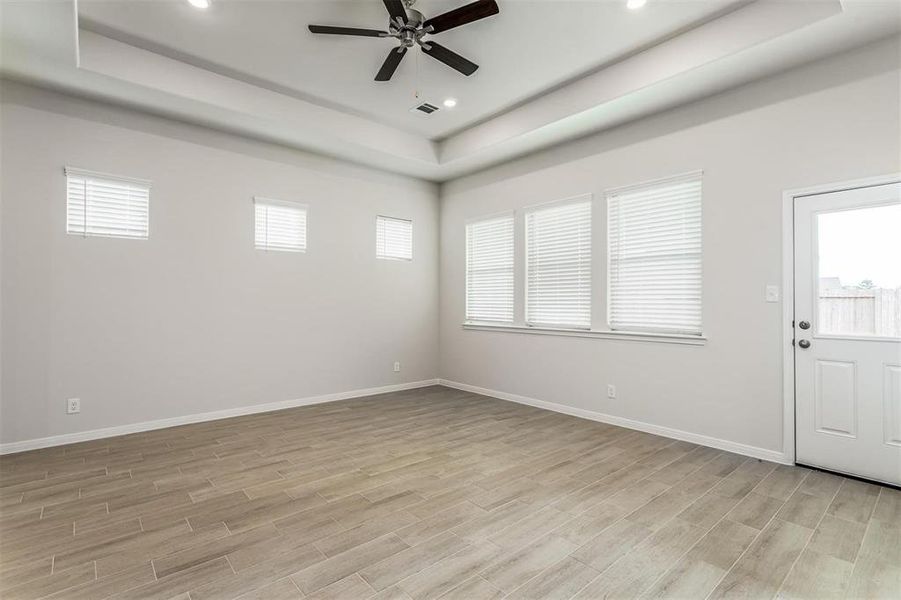 Relax and unwind in this expansive living room, featuring large windows that let in plenty of natural light. The ceiling fan adds comfort, while the neutral color palette provides a serene backdrop for your decor. This versatile space is perfect for family gatherings and casual lounging. Photos are from another Rylan floor plan.