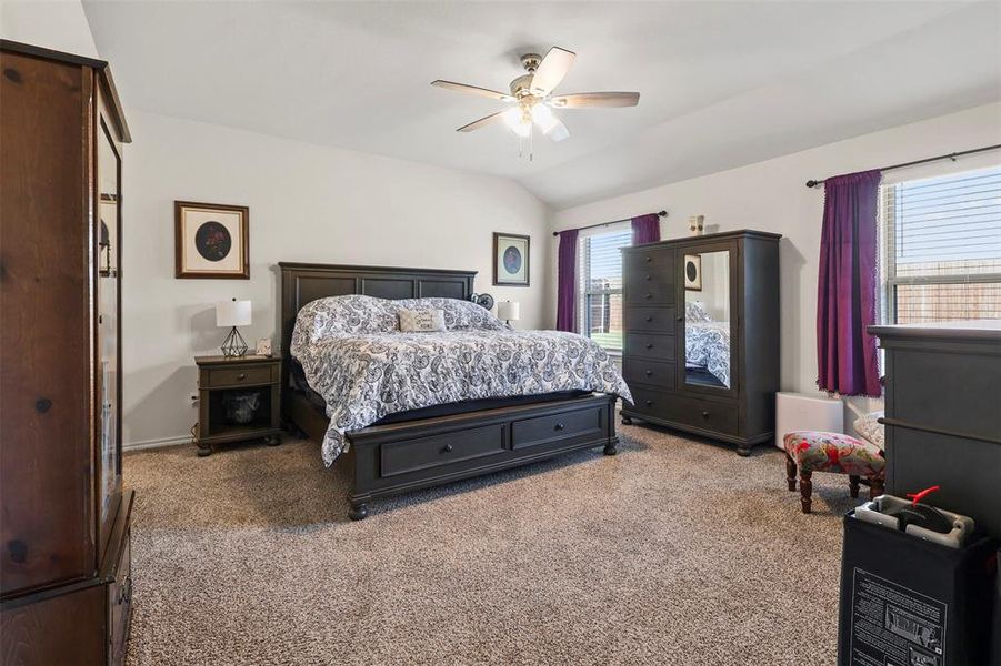 Bedroom featuring carpet, ceiling fan, and vaulted ceiling