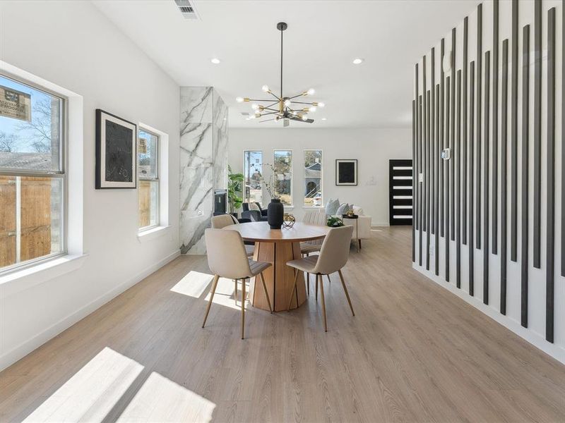 Dining area featuring recessed lighting, visible vents, a notable chandelier, and light wood-style flooring